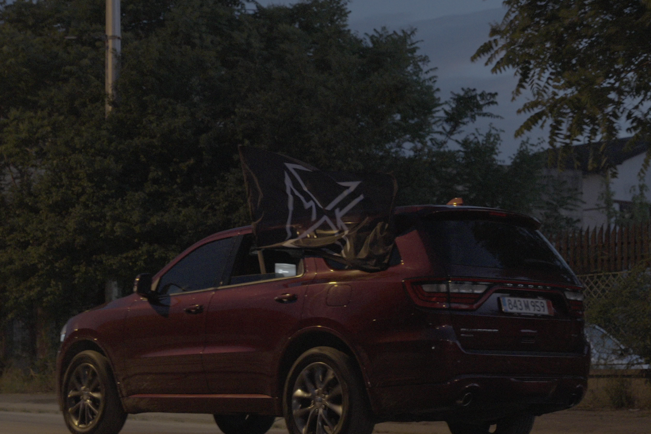PSMK flag waving from a car window at night